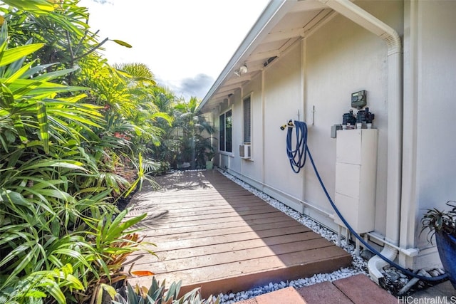 view of property exterior with a wooden deck and cooling unit