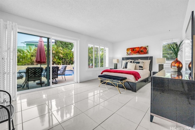 bedroom featuring light tile patterned flooring, a textured ceiling, and access to outside