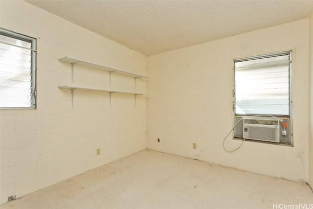 empty room featuring cooling unit and a textured ceiling