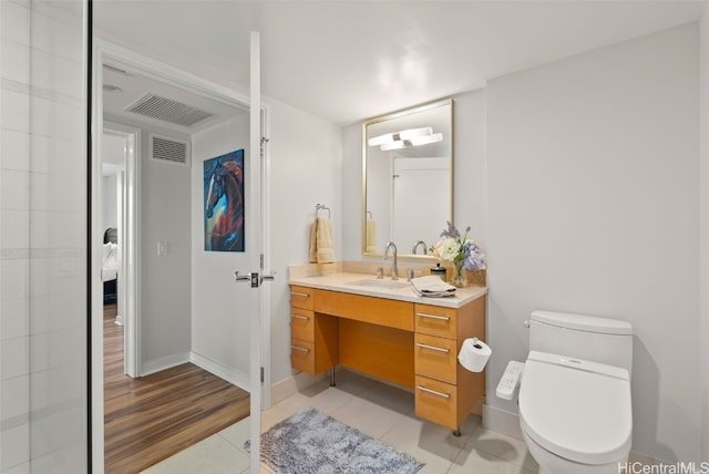 bathroom featuring vanity, tile patterned floors, and toilet