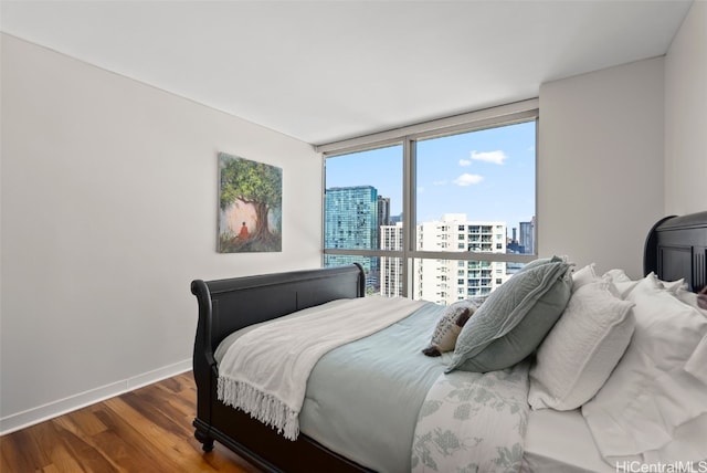 bedroom with hardwood / wood-style floors and floor to ceiling windows