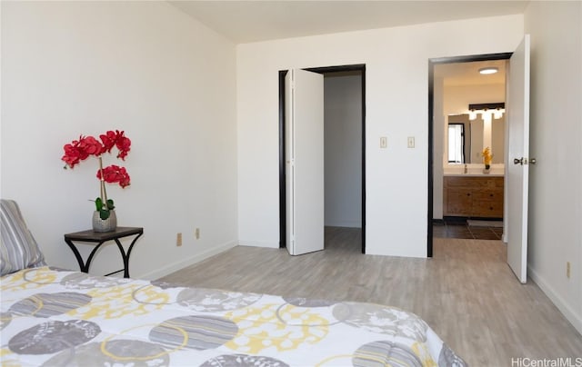 bedroom featuring sink and light hardwood / wood-style flooring