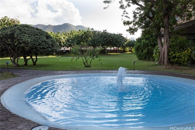 view of pool featuring a mountain view and a lawn