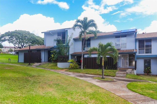 view of front facade featuring a front lawn and solar panels