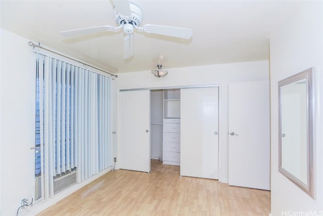 unfurnished bedroom with ceiling fan, a closet, and light wood-type flooring