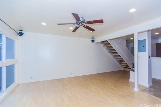 unfurnished living room featuring light hardwood / wood-style flooring, electric panel, and ceiling fan