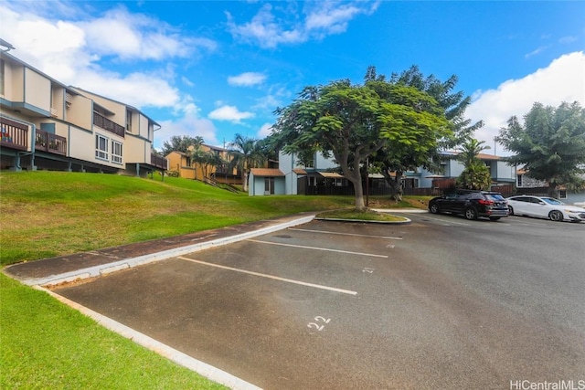 view of parking / parking lot with a lawn