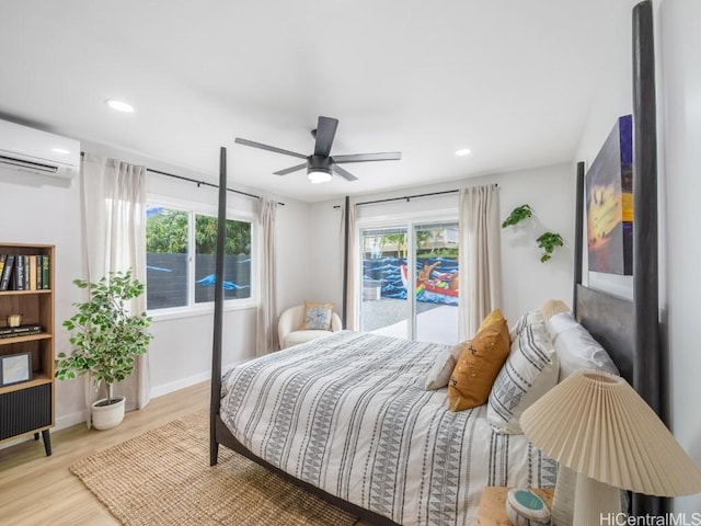 bedroom with multiple windows, access to outside, ceiling fan, a wall unit AC, and light hardwood / wood-style flooring