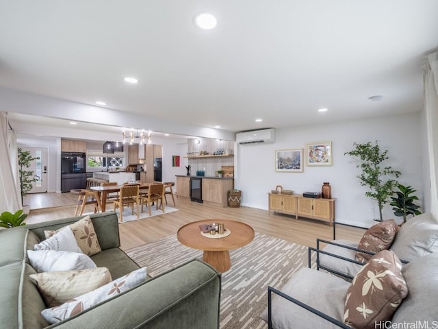 living room featuring a wall mounted AC and light hardwood / wood-style floors