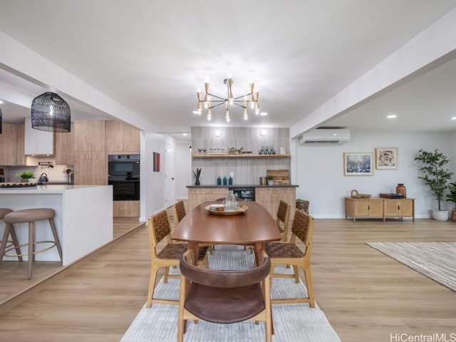 dining space with beverage cooler, a chandelier, a wall mounted AC, and light wood-type flooring