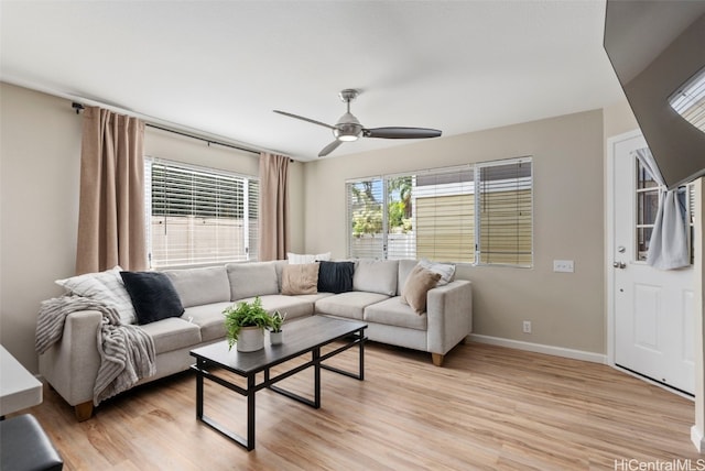 living area featuring light wood-type flooring, ceiling fan, and baseboards