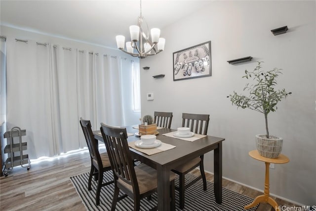 dining space featuring light hardwood / wood-style flooring and a notable chandelier