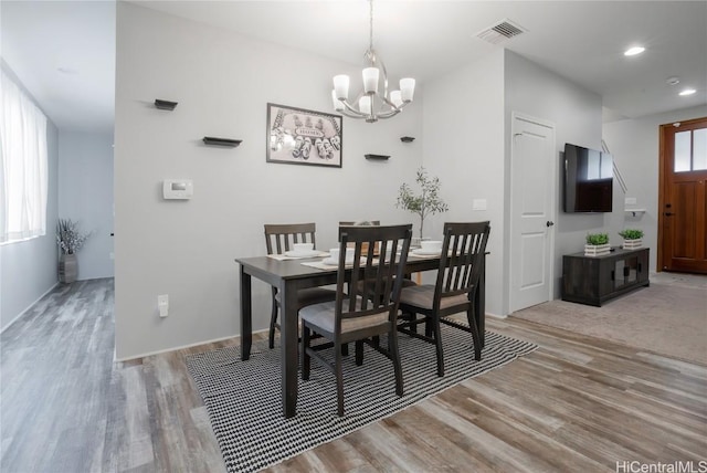 dining space featuring an inviting chandelier and light wood-type flooring