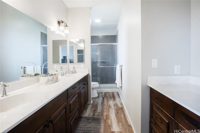 bathroom with vanity, toilet, an enclosed shower, and wood-type flooring