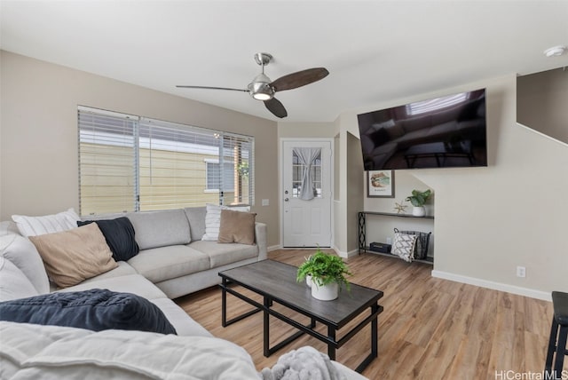 living room featuring light wood-type flooring, ceiling fan, and baseboards