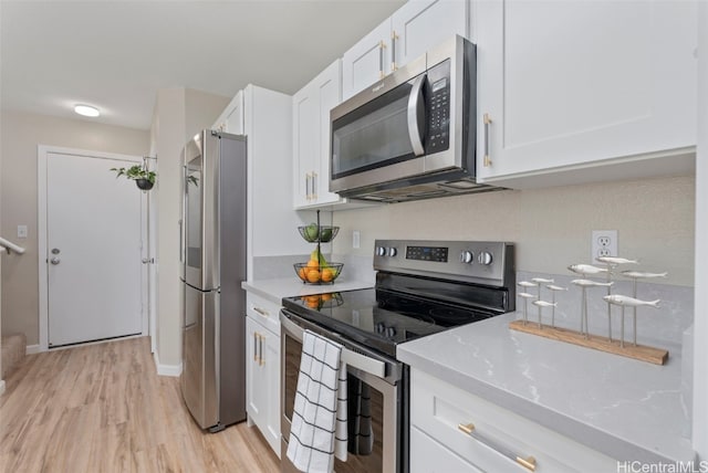 kitchen with stainless steel appliances, light wood-type flooring, and white cabinets