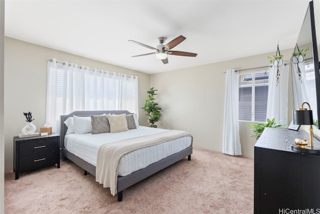 bedroom with light carpet, ceiling fan, and multiple windows