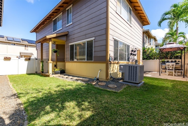 rear view of property with cooling unit, a patio area, a yard, and a fenced backyard