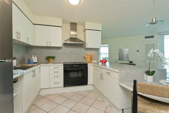 kitchen with white cabinets, wall chimney range hood, backsplash, and black / electric stove