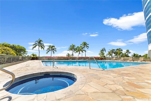 view of pool with a hot tub