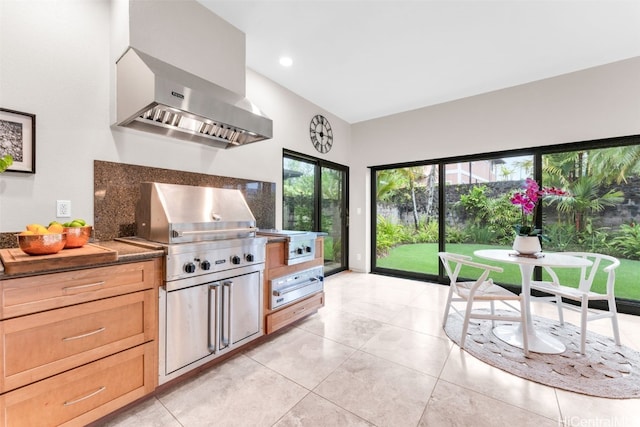 kitchen featuring wall chimney range hood and backsplash