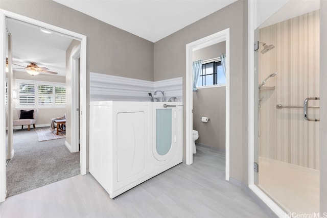 laundry area featuring ceiling fan and light colored carpet