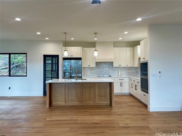 kitchen featuring white cabinetry, stainless steel fridge, custom exhaust hood, and a kitchen island