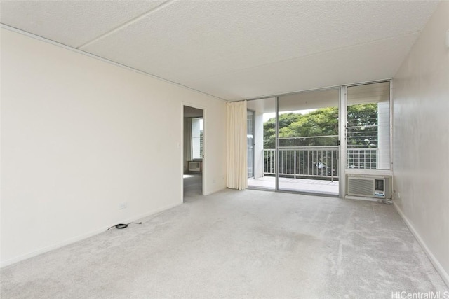 spare room with cooling unit, light colored carpet, floor to ceiling windows, and a textured ceiling