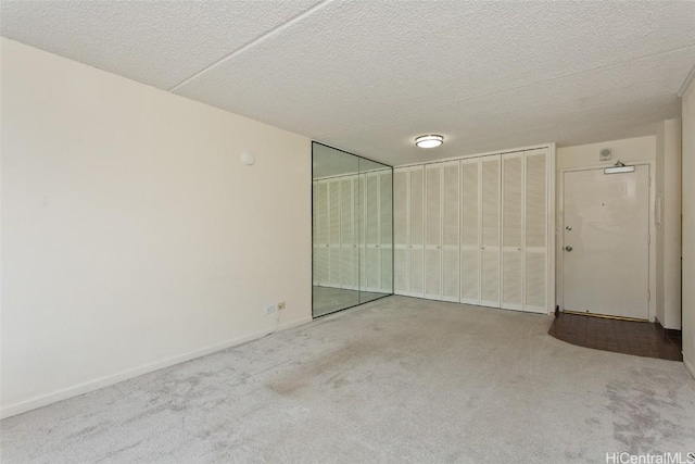 carpeted spare room with a textured ceiling