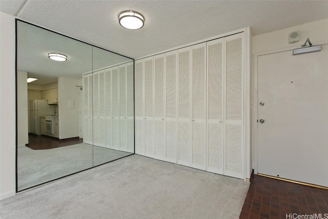 unfurnished bedroom featuring a textured ceiling and white refrigerator