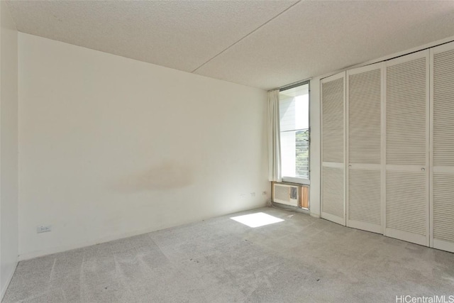 unfurnished bedroom featuring light carpet, a textured ceiling, and a closet