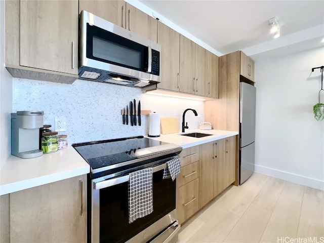 kitchen featuring stainless steel appliances, tasteful backsplash, sink, and light brown cabinets