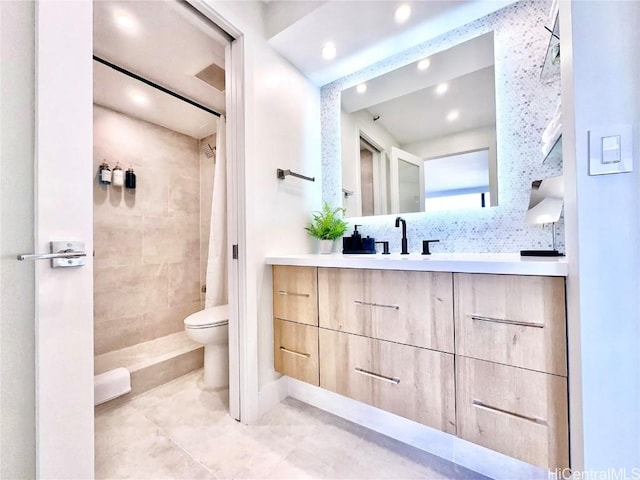 bathroom with vanity, toilet, tile patterned flooring, and a tile shower