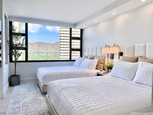 bedroom featuring a mountain view and light hardwood / wood-style floors