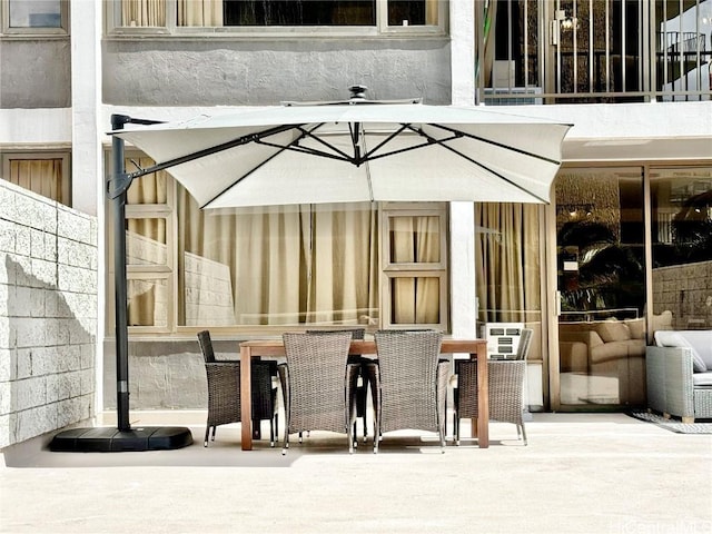 view of patio with a balcony and outdoor dining area