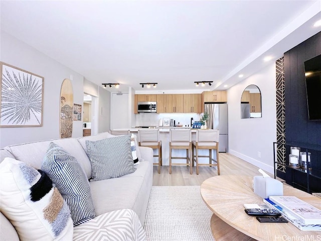 living area with light wood-style flooring and baseboards