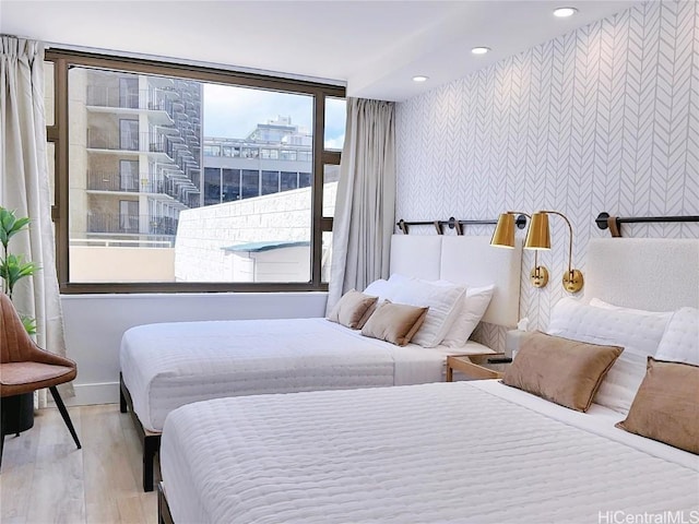 bedroom featuring baseboards, wood finished floors, and recessed lighting