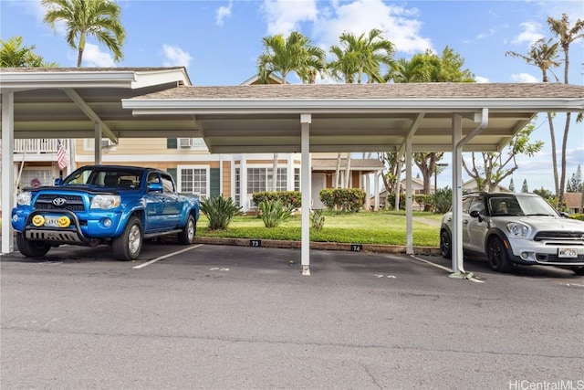 view of vehicle parking with a carport and a lawn