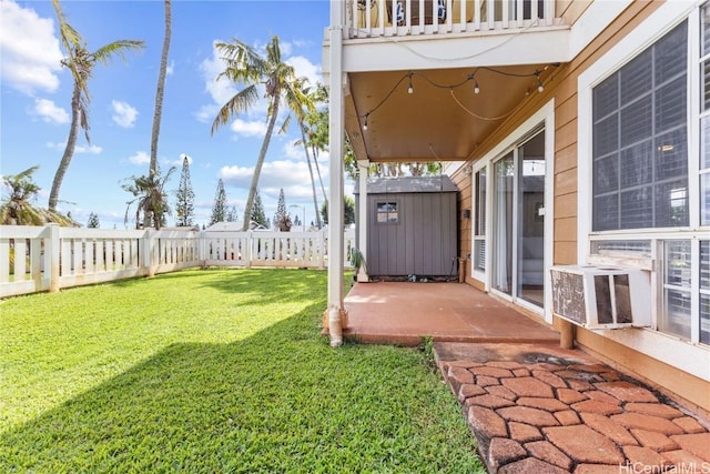 view of yard featuring a balcony, a storage unit, and a patio area