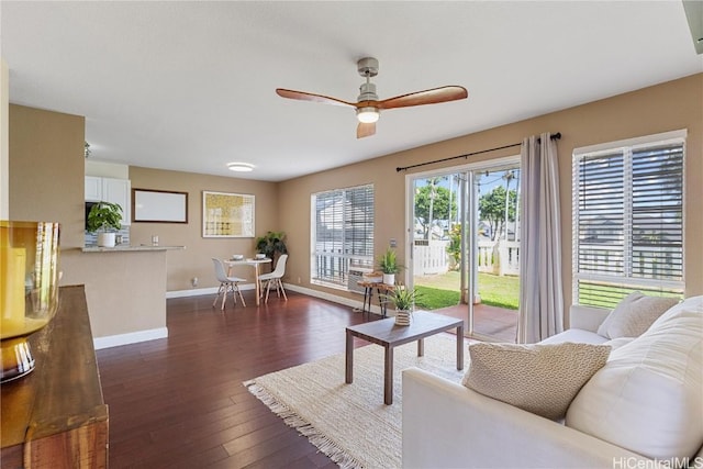 living room featuring dark wood-type flooring and ceiling fan