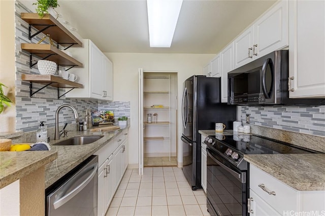 kitchen with light stone counters, appliances with stainless steel finishes, sink, and white cabinets