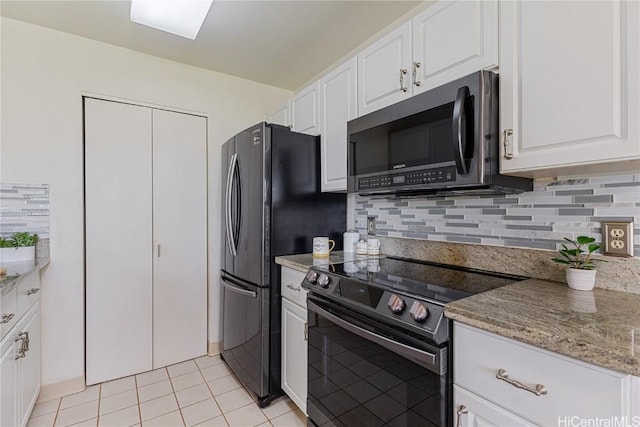 kitchen featuring light stone counters, tasteful backsplash, electric range oven, light tile patterned floors, and white cabinets