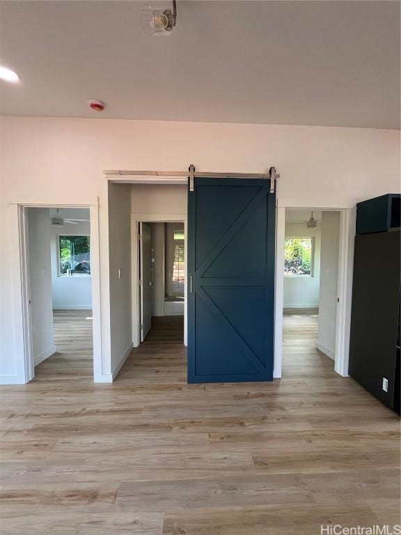 spare room featuring a barn door and light wood-type flooring