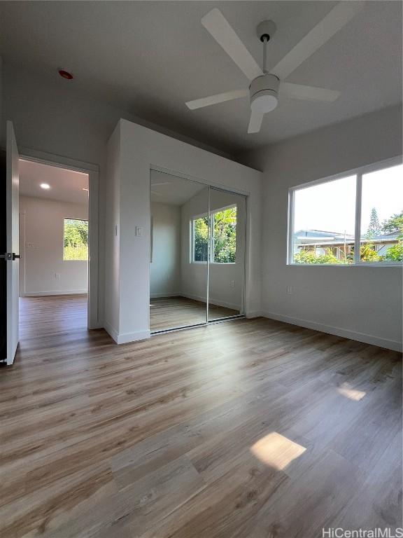 unfurnished bedroom with a closet, ceiling fan, and light wood-type flooring