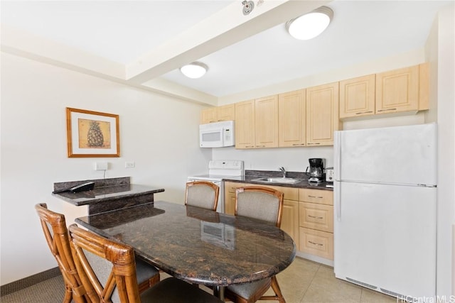 kitchen featuring sink, light tile patterned floors, light brown cabinets, kitchen peninsula, and white appliances