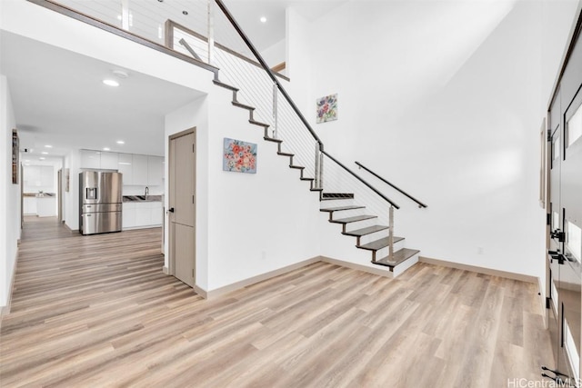 entryway featuring a towering ceiling and light hardwood / wood-style floors