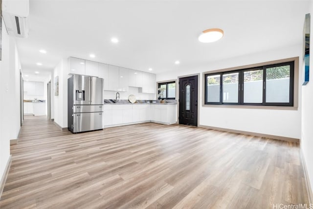 unfurnished living room featuring sink and light hardwood / wood-style floors