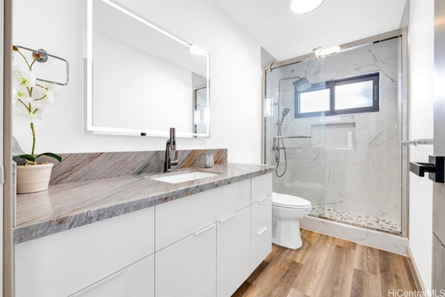 bathroom with vanity, hardwood / wood-style floors, toilet, and an enclosed shower