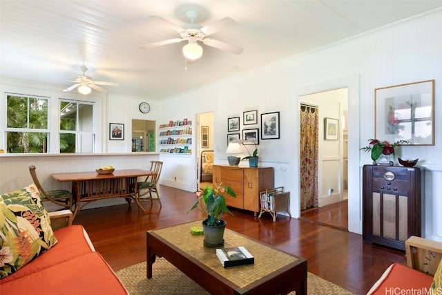 living room with crown molding, dark hardwood / wood-style floors, and ceiling fan