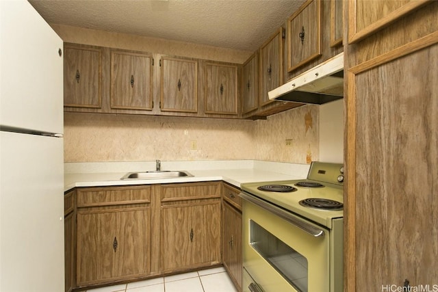 kitchen with light tile patterned flooring, sink, white refrigerator, electric range, and a textured ceiling